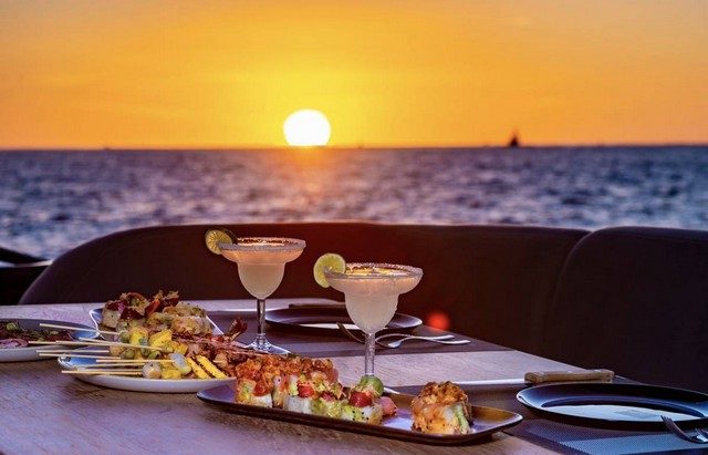 Margaritas and appetizers on a yacht table at sunset